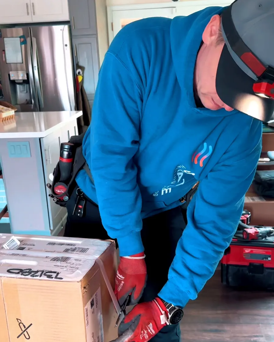 Seattle Heating & Cooling tech unboxing new equipment in a customer's kitchen