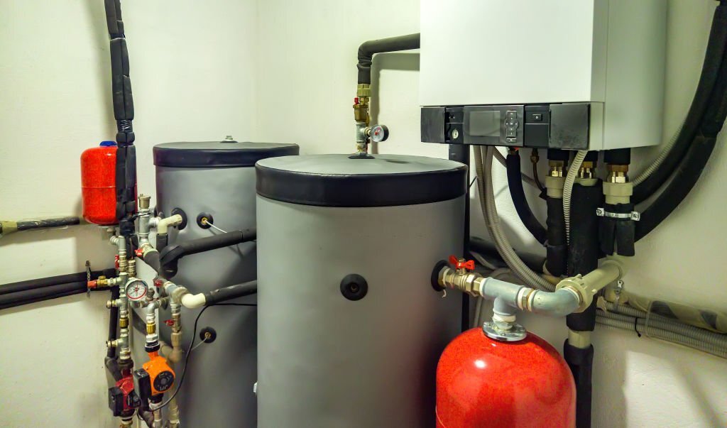 seattle heating cooling services by product lennox Kirkland - Seattle Heating & Cooling A boiler room with insulated water tanks, pipes, and a heating system, including a red expansion tank and various valves.