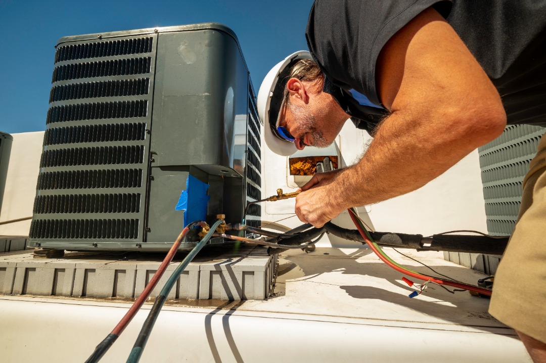 seattle heating and cooling ac repair kirkland - Seattle Heating & Cooling An HVAC professional in the middle of welding small pipes together to wrap up an A/C repair service.