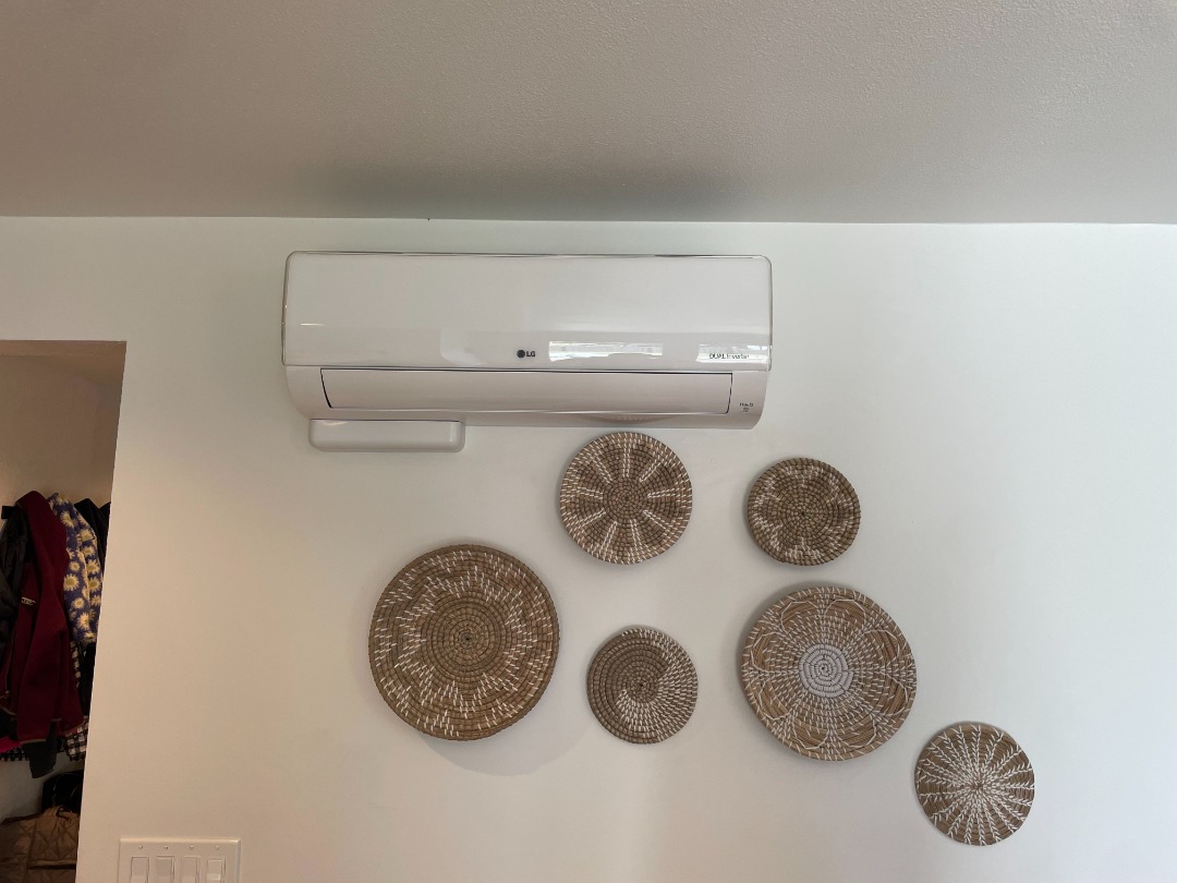 seattle heating cooling edmonds bosch day and night - Seattle Heating & Cooling LG mini-split air conditioner mounted above woven decorative wall plates in a modern interior with neutral decor.