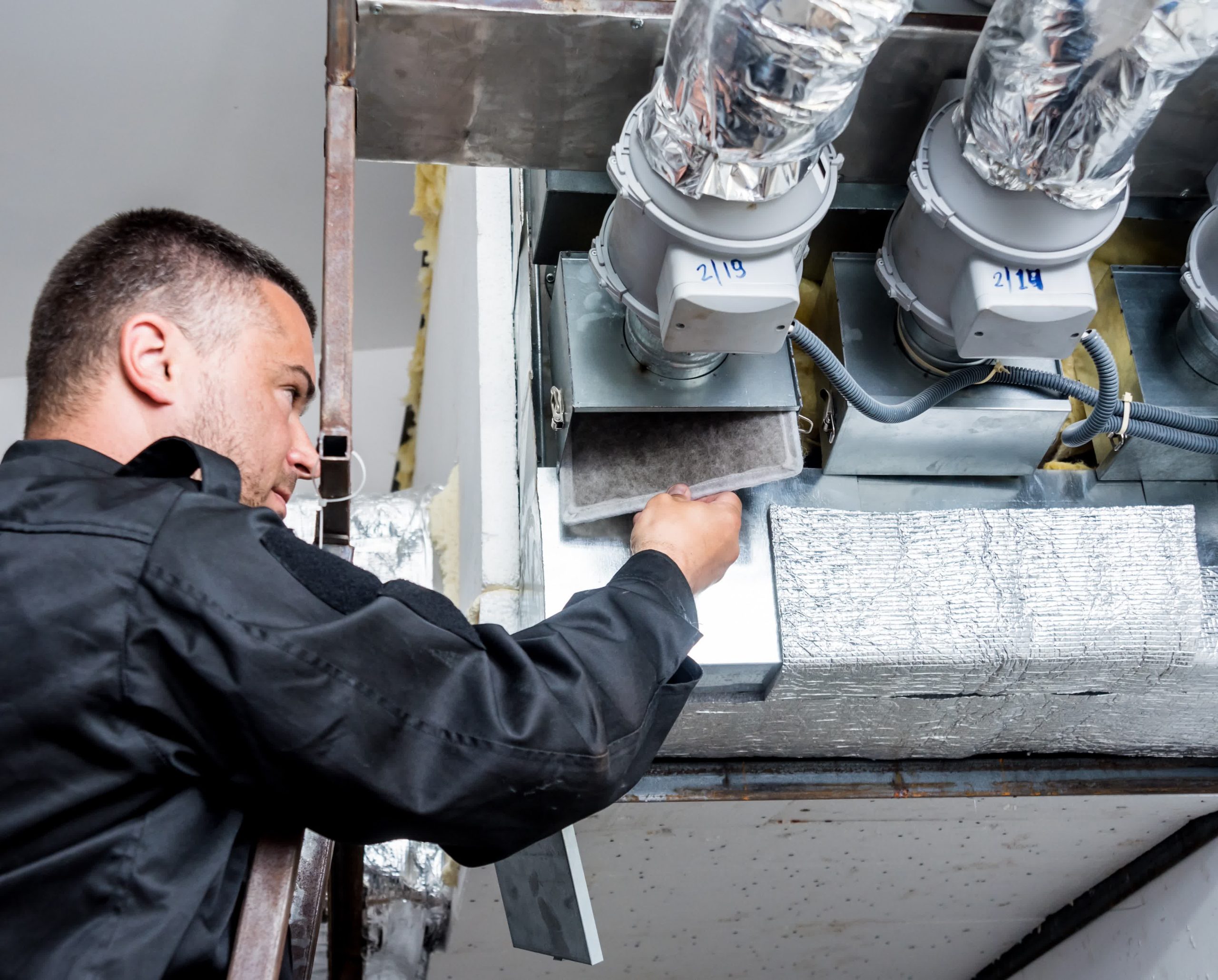 An expert checking an air filter to diagnose the cleanliness of an air duct.
