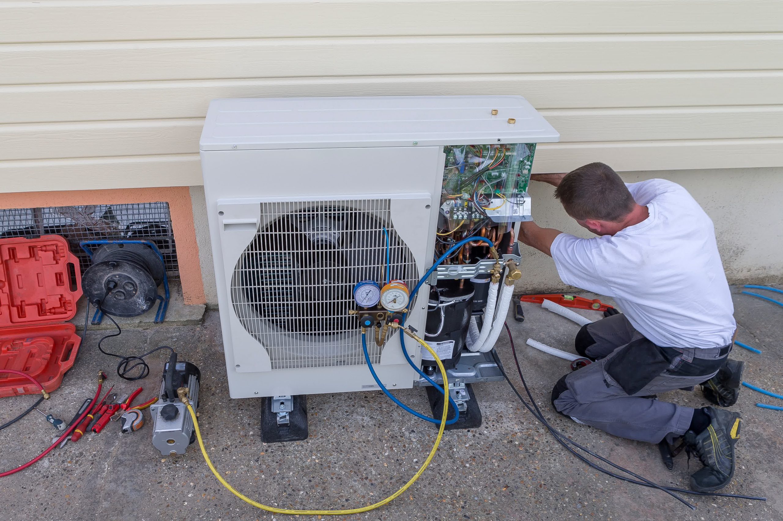 An HVAC technician taking care of an A/C repair job.

