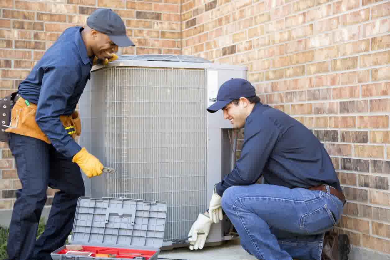 A couple of professionals are installing a new AC unit.
