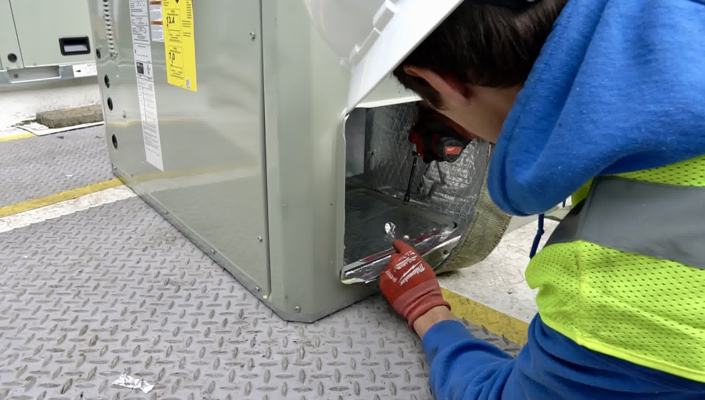 A quick AC repair is being taken care of by a professional.