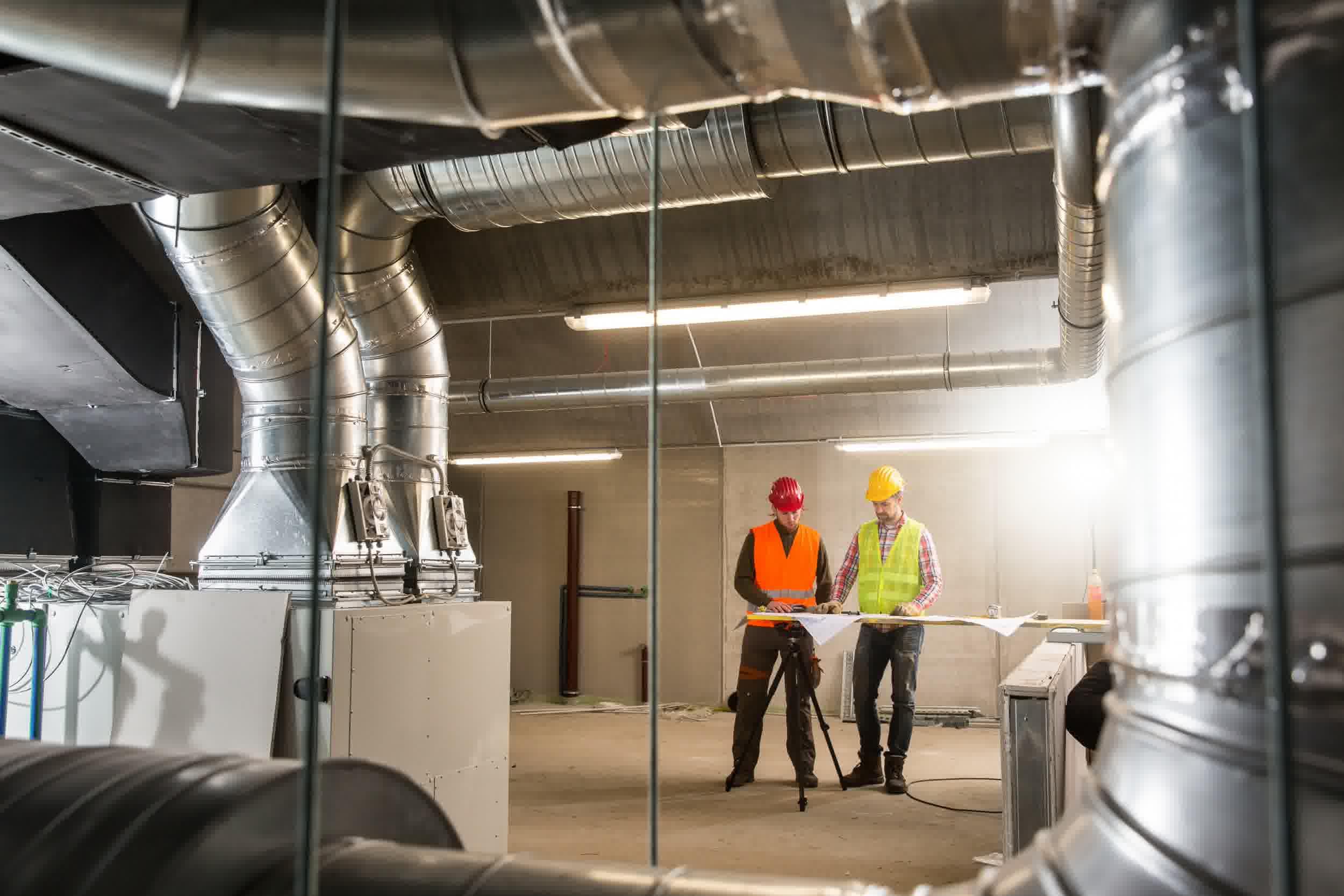 A couple of HVAC technicians coming together for a duct repair service.
