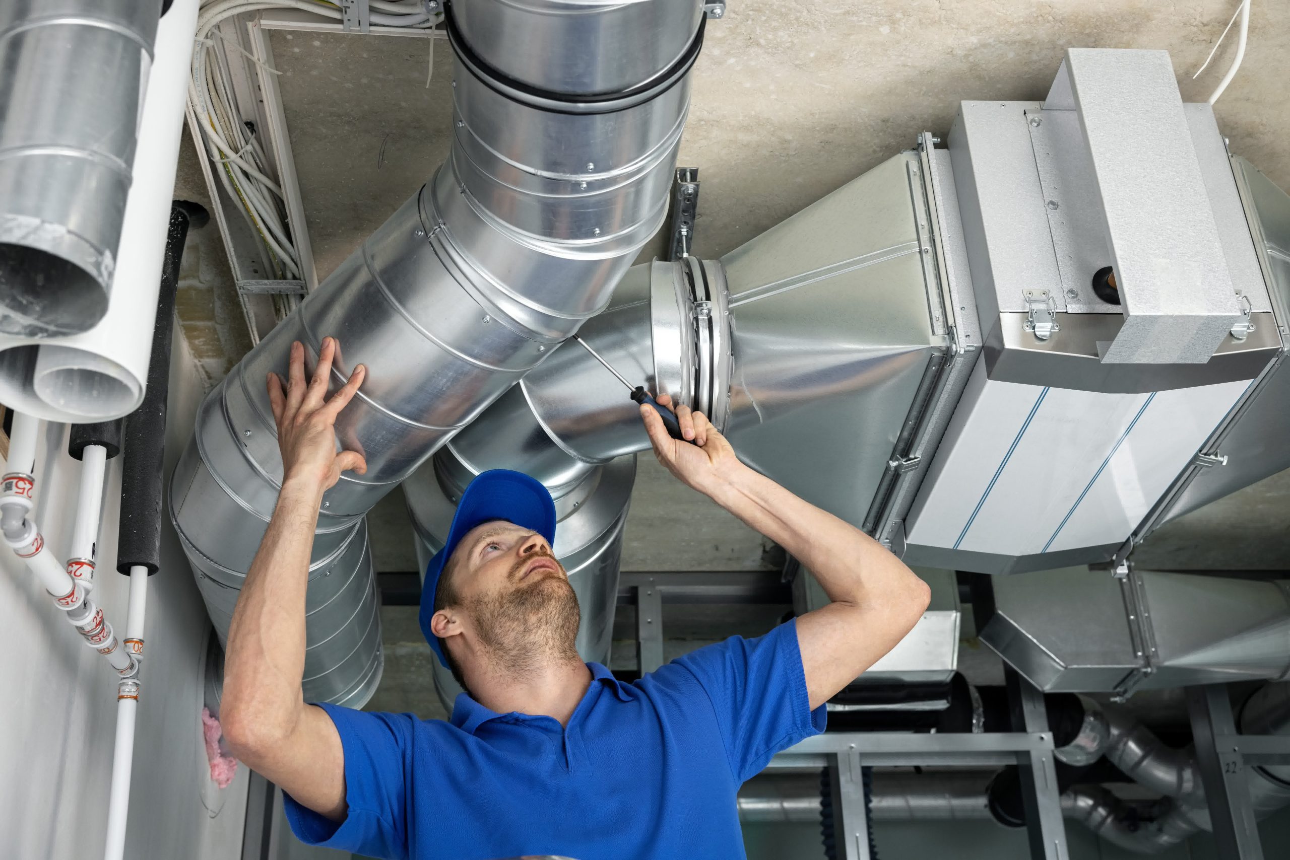 An HVAC technician wrapping up an air duct repair and cleaning service.